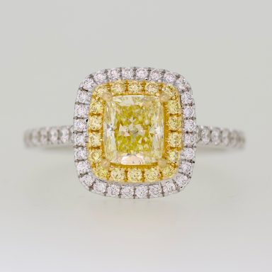 Anillo de compromiso con diamante amarillo en el centro, rodeado de diamantes amarillos y blancos.